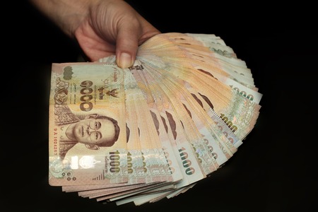 Use hand wipes 1000 Baht of Thailand banknotes with black backgroundの写真素材
