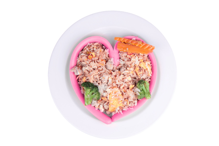 Pink Sausage cheese in heart style wrap fried pink jasmine rice with pork and egg topped carrot and Broccoli on white plate.の写真素材