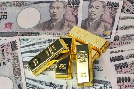 5 of  999.9 % of 1000 g Gold bars  placed on dallar banknotes and Yen bank notesの写真素材
