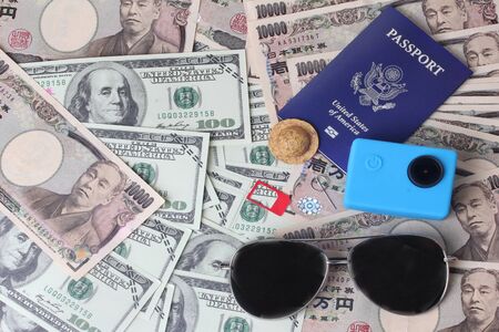 Passport ,eye glasss,small hat ,action camera and socket sim place on banknote for relaxating and tourism,Overhead view of Traveler's accessories,Time of award of work, Essential vacation items, Travel concept background.の写真素材