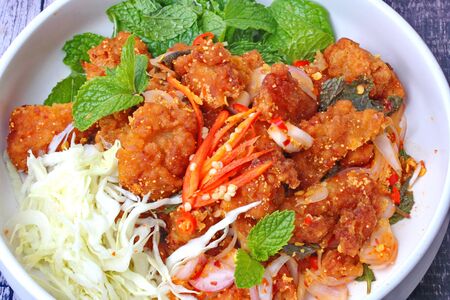 Thai food, Spicy crispy deep-fried chicken salad call Yum Kai Zap in Thai topped shredded cabbage and Kaffir lime leaves.の写真素材