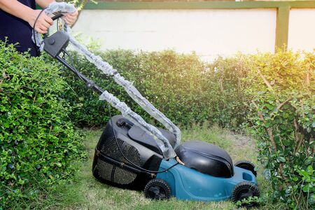 Use hands to push mower to cut the grass in garden of  houseの写真素材