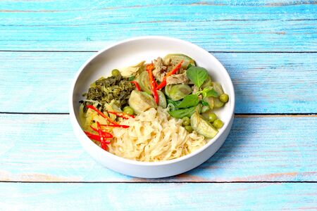 Isolated of popular Thai food, Chinese noodle with green chicken curry in coconut milk topped minced pickle lettuce.の写真素材