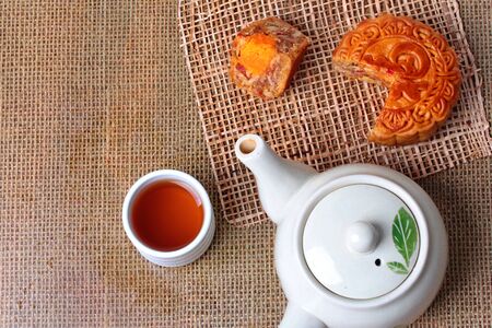 Round mooncake filled
8 grains and salted eggs served with tea and teapot.の写真素材