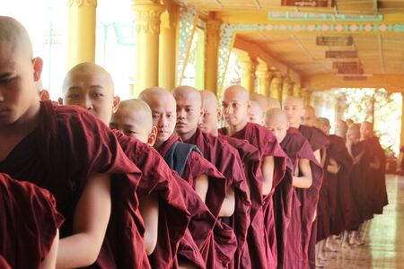 Bago City, Myanmar - 4 Feb 2018 : Monks walked in line to receive rice from the people who were waiting to give food at  kyakhat wine monastery, Shwemawdaw paya Hongsawadeeのeditorial素材