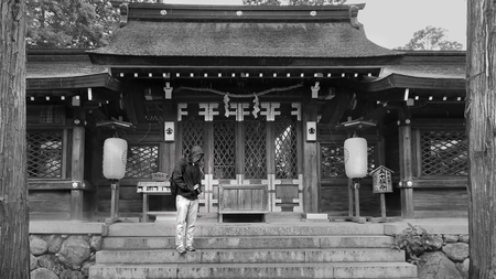 Wakayama City,Japan,14 July 2019,Black and white photo of Tourist Backpacker teen is standing and protecting  body and  DSLR camera in font of Buddhist building of  Itakiso Jinja Shrine.のeditorial素材