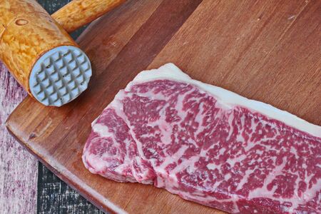 Ready raw fresh steak as wagyu beef  MS5+ with meat hammer  on butcher served  for cooking .の写真素材