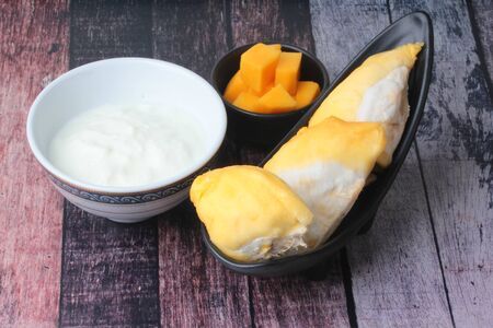 Natural  yogurt serve with the popular Thai fruits as ripe Chanee Durian and ripe cubed mango ,the most delicious duriran of Thailandの写真素材