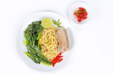 Ramen noodle, topped Chinese kale and streamed streaky pork in soup with halve green lemon and sliced chili and minced chiliの写真素材