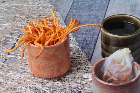 Golden cordyceps mushroom in cup   served on woodの写真素材