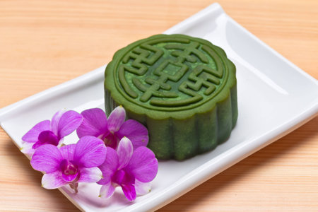 Mid-Autumn Festival moon cake on wooden board with Orchid  flowerの写真素材