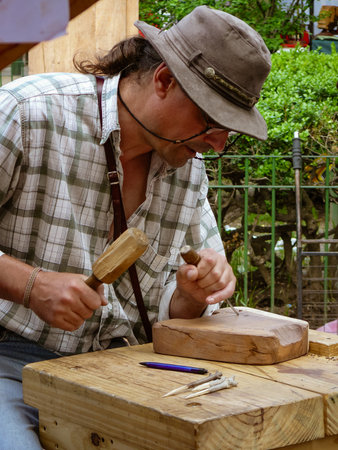 Artisan working on the wood with a gouge and a hammerのeditorial素材