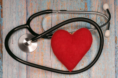 Corduroy red heart with a stethoscope on a light rustic wood backgroundの写真素材