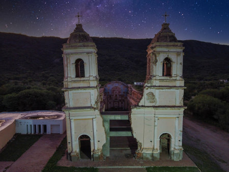 Frontal night view of the church in Ambil, La Rioja. The starry sky serves as a backdrop, and artificial lighting reveals the ruins and the leaning tower.の写真素材