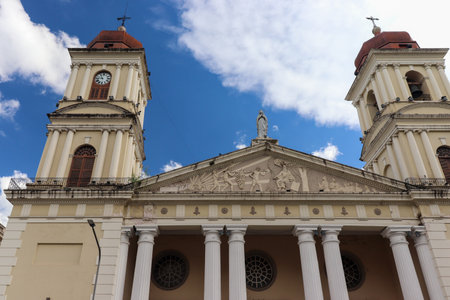 Imposing view from below of the two towers and columns of the Tucuman Cathedral. Appreciate its architectural grandeur on a summer afternoon with a partially cloudy sky.の写真素材