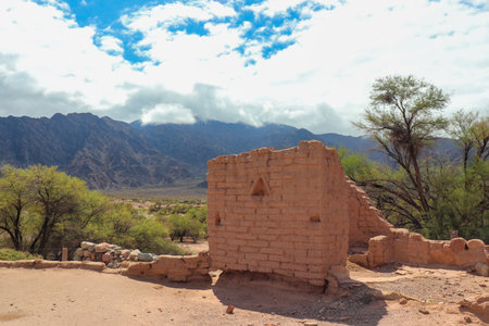 Vestiges of ancient adobe constructions under the blue sky, in the picturesque mountainous landscape of Mayorazgo de Catamarca, Argentina.の写真素材