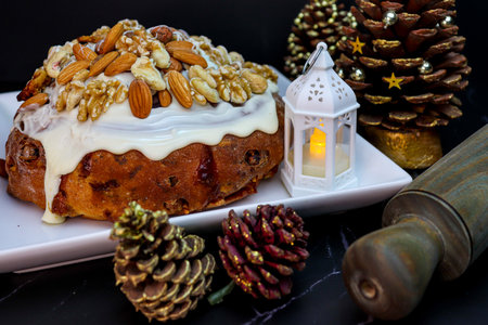 Pan Dulce with glaze, dried fruit, pine cones and a lantern. Christmas celebration and end of year party with dark styleの写真素材