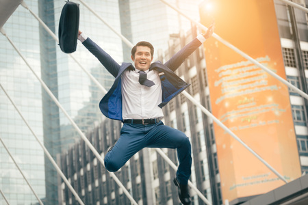 A business man jump to catch the sunlight because of successの写真素材