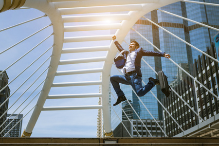 A business man jump to catch the sunlight because of successの写真素材