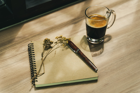 A coffee and a book on wood desk setting in idea and chilling conceptの写真素材