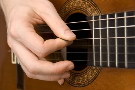 Close-up of a spanish guitar being played using a plectrum