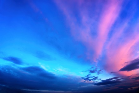 Twilight sky background in deep blue with vivid pink cloudsの写真素材