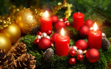 Studio shot of a nice advent wreath with baubles and three burning red candles Studio shot of a nice advent wreath with baubles and three burning red candles