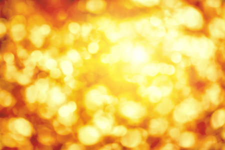Shining out-of-focus highlights in gold and yellow, a bright bokeh background ideal for autumn or Christmasの写真素材