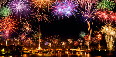 Cheerful fireworks display in the city, with lots of colorful bangs rising high into the night sky, with black copyspaceの写真素材