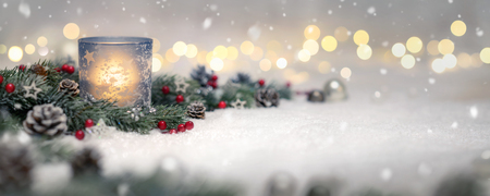Christmas decoration with candle, lights, fir branches and ornaments on snow, panoramic formatの写真素材