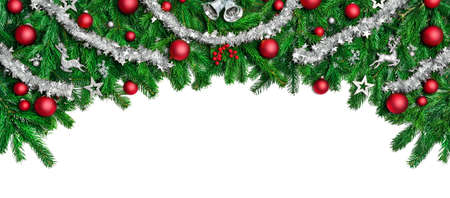 Wide arch shaped Christmas border isolated on white, composed of fresh fir branches and ornaments in red and silverの写真素材