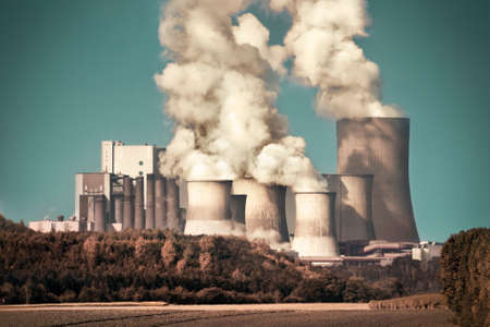 Large coal power plant with steam and smoke on teal sky, dramatic lookの写真素材