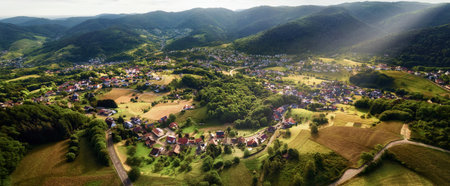 Aerial panorama of a scenic landscape with an idyllic European town surrounded with hills, forests and fieldsの写真素材
