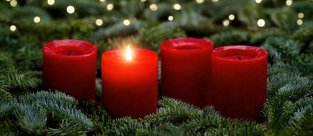 Red Advent candles, one burning, with fir branches and bokeh lights. The image is part of a set.の写真素材