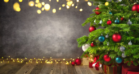Delightful Christmas tree closeup with textured gray wall as a nice background framed with lights and vignettingの写真素材