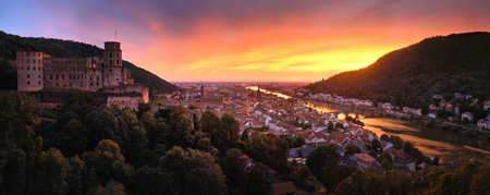 Heidelberg, Germany, aerial panoramic view at dusk, with dramatic colorful sunset sky, the castle, Neckar river and the Old Bridgeの写真素材