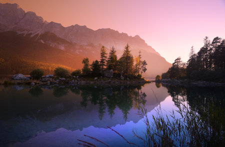 Idyllic lake at sunrise, a picturesque scenery with majestic mountains and the golden sunlight...