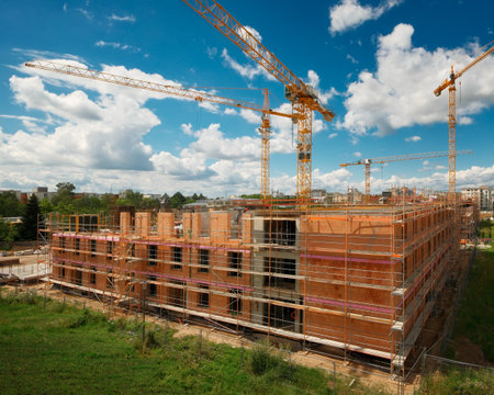 Construction site with several cranes over nice blue sky, with nobody and no logosの写真素材