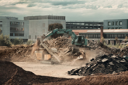 Construction site with excavator and conveyor at work. Industrial action with machinery and dust in broad daylightの写真素材