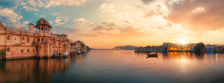Udaipur, Rajasthan, India, at sunset. Panoramic landscape with dramatic beautiful sky and the setting sun at the lakeの写真素材