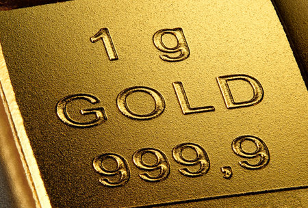 Extreme closeup of a 1 gram piece of pure gold. Finance concept for the high price at the gold...