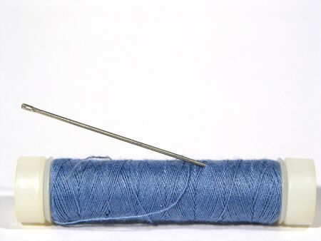 Close-up of spool of blue garn and a needle