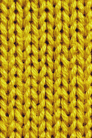 Photo of Bright Yellow Knitted Texture for Universal Application. Background Top View Knitting Textile Fabric from Wool.の写真素材