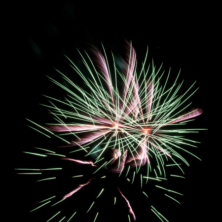 green and pink fireworks on black backgroundの写真素材