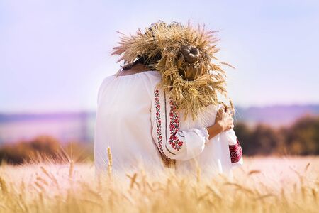 Mom and daughter are sitting in a wheat fieldの写真素材