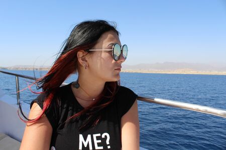 A sweet brunette sails on a yacht in the red seaの写真素材