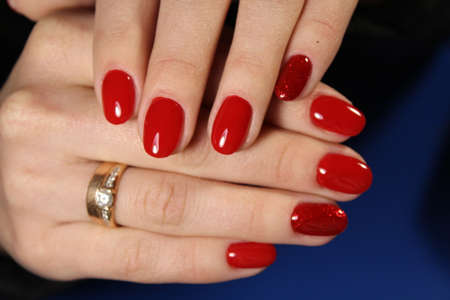 Stylish trendy female manicure. Beautiful young woman's hands on pink and blue background.
