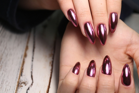 Gorgeous manicure, dark purple tender color nail polish, closeup photo. Female hands over simple...