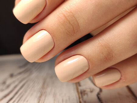 Glamorous luxurious brown crocodile manicure with gold plated women's nails closeup.
