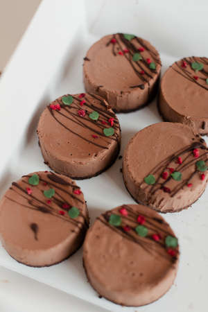 Cupcake stand. A box of cakes. Delicious dessert as a gift. Chocolate dessert in a package. Cakes on a light backgroundの写真素材